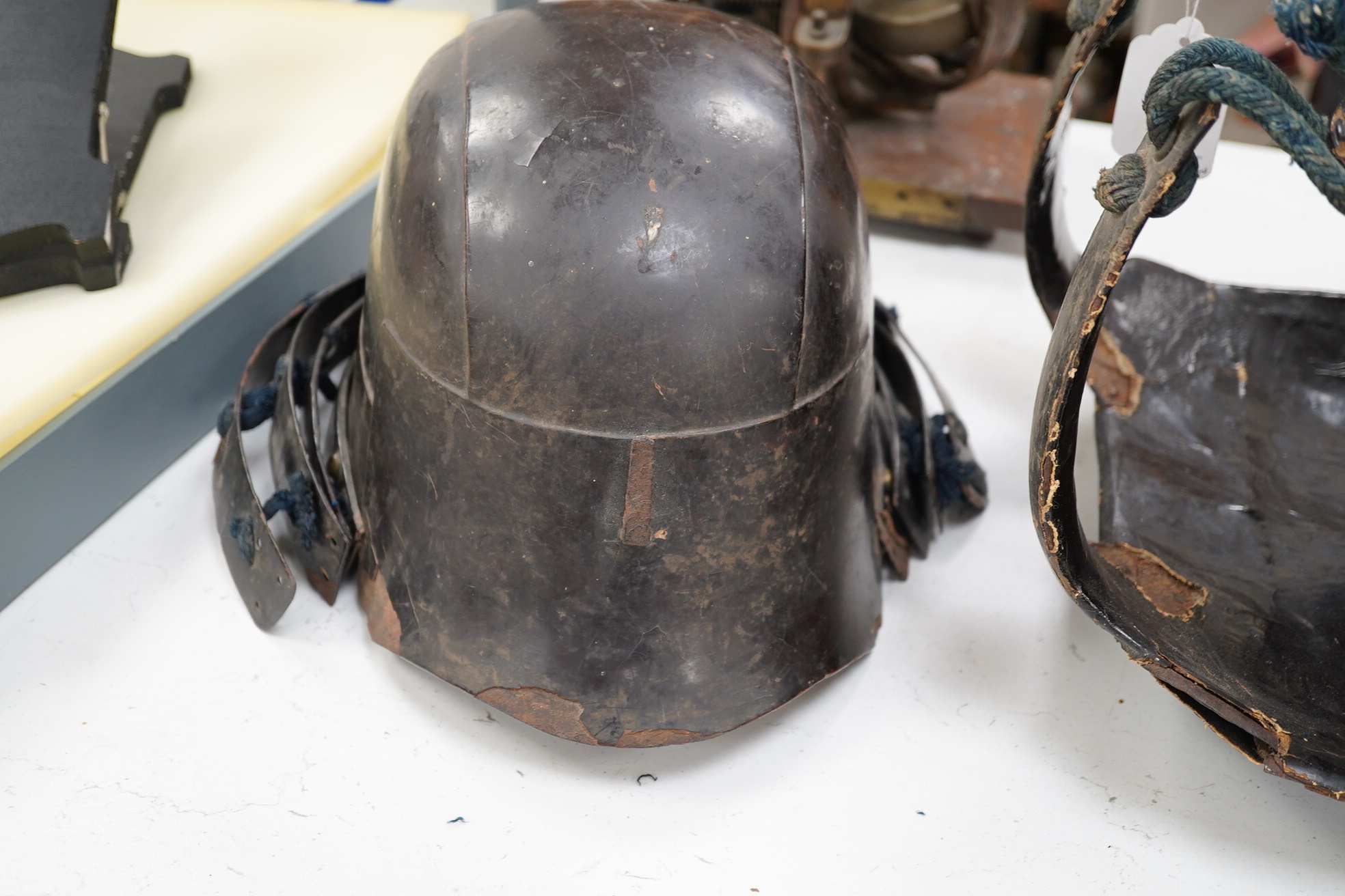 A Japanese armour, 19th century or earlier comprising; helmet Kabuto of five plates covered in black lacquer with 4-plate shikoro, also an iron lacquered mempo with three lames to throat and a do opening at side, embosse